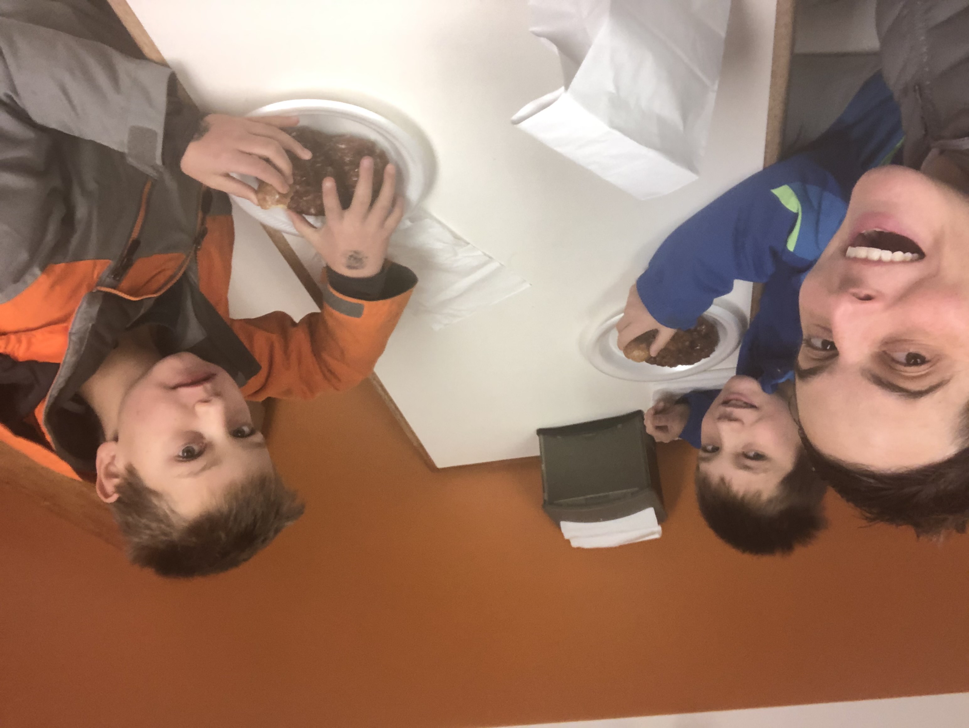 Mom and two sons eating donuts